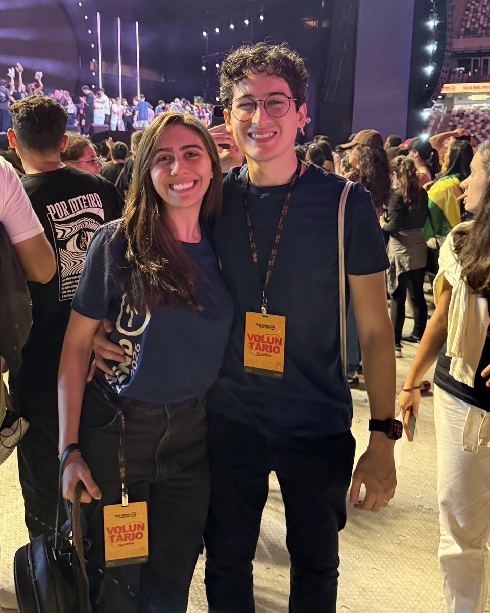 Gabriel and Rebecca smiling together among a crowd at an event.